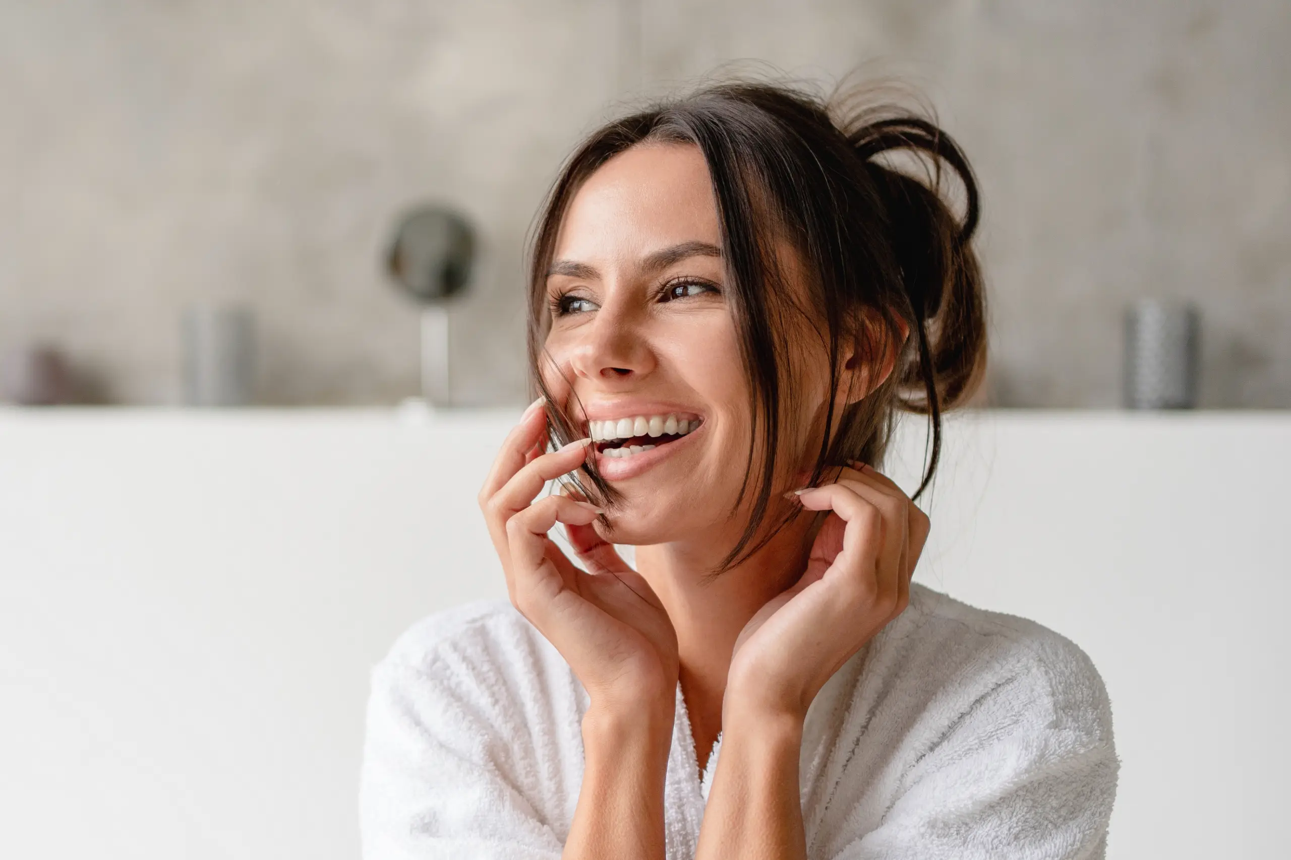 Laughing woman with her hands near her face